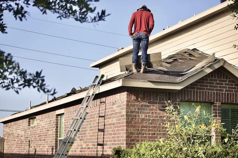 Professional roofer working on a residential roof in Half Hollow